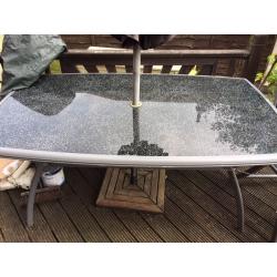 Large glass table and 4 chairs plus parasol and base