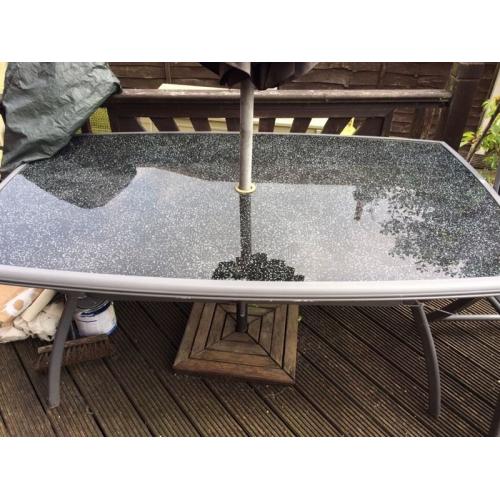 Large glass table and 4 chairs plus parasol and base