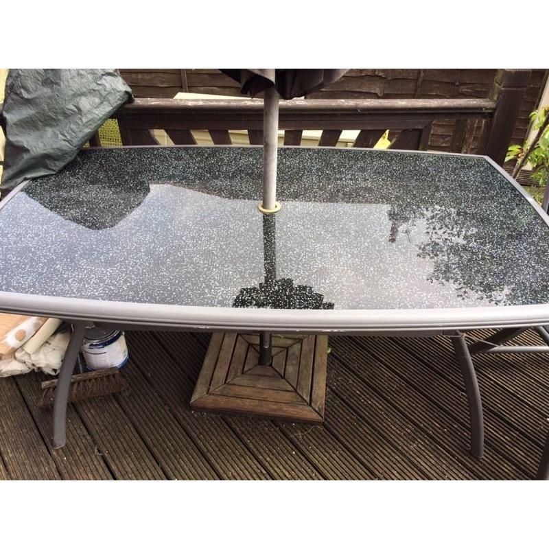 Large glass table and 4 chairs plus parasol and base