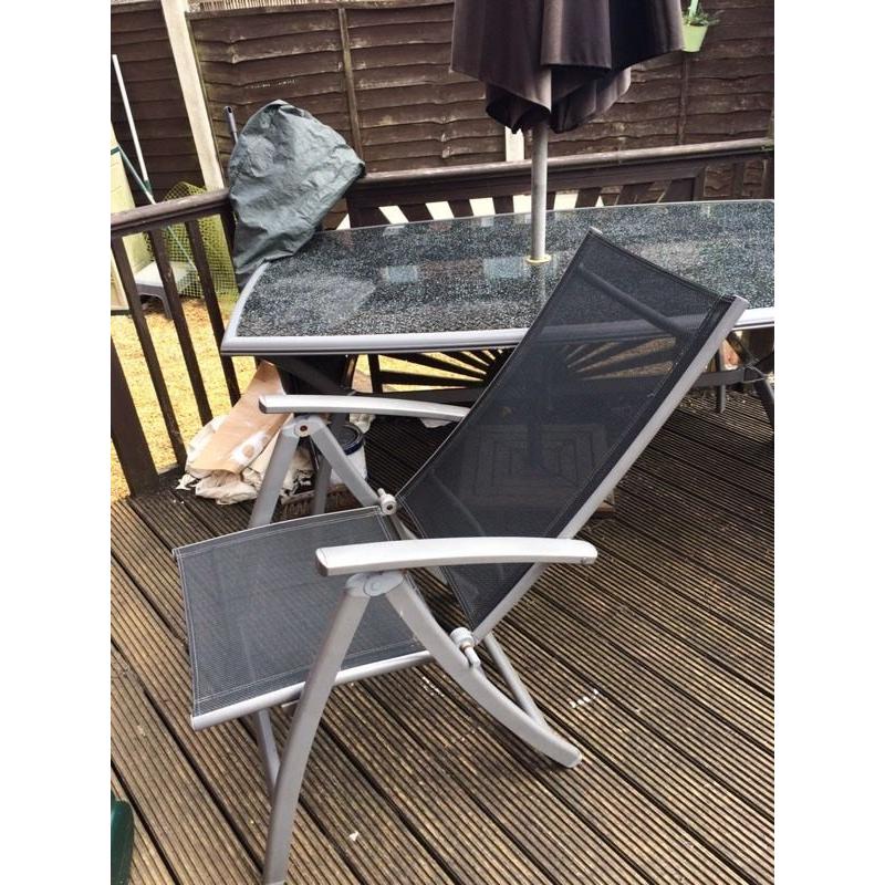 Large glass table and 4 chairs plus parasol and base