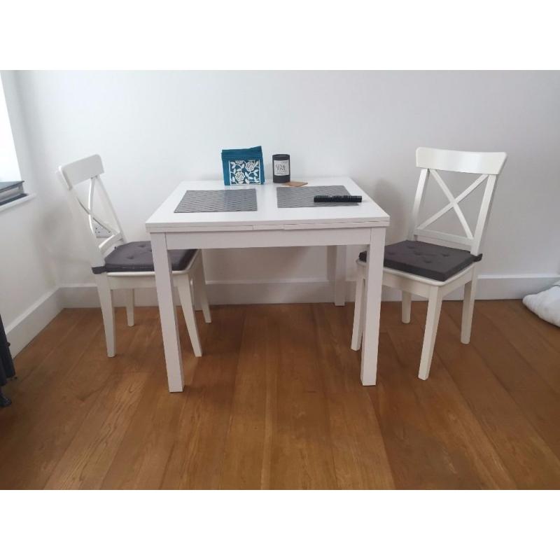 Nearly new extendable table with two chairs (including grey cushions)