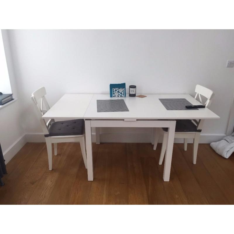 Nearly new extendable table with two chairs (including grey cushions)
