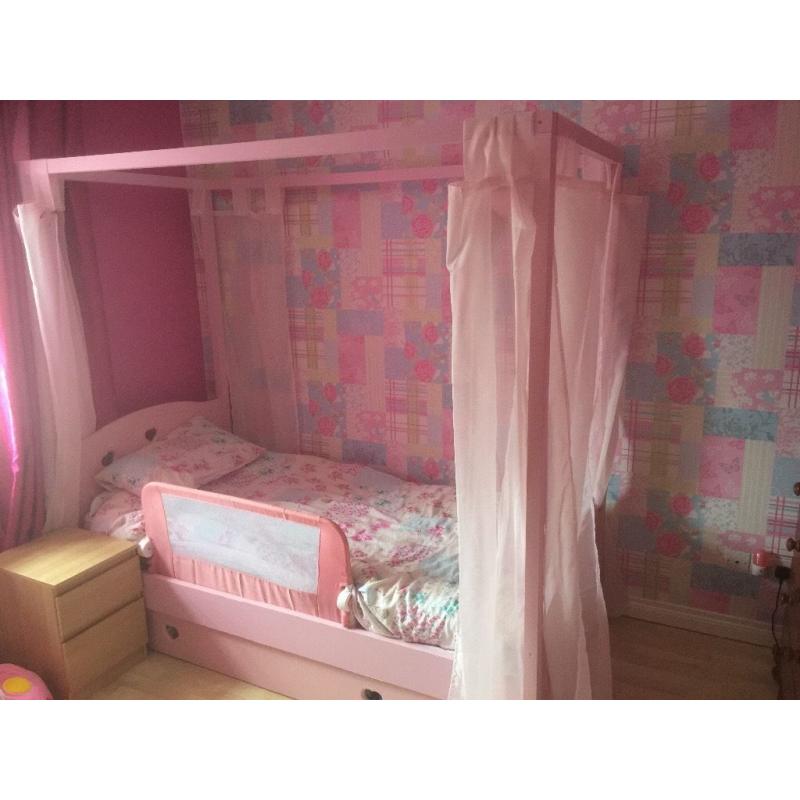 Pink wooden four poster bed