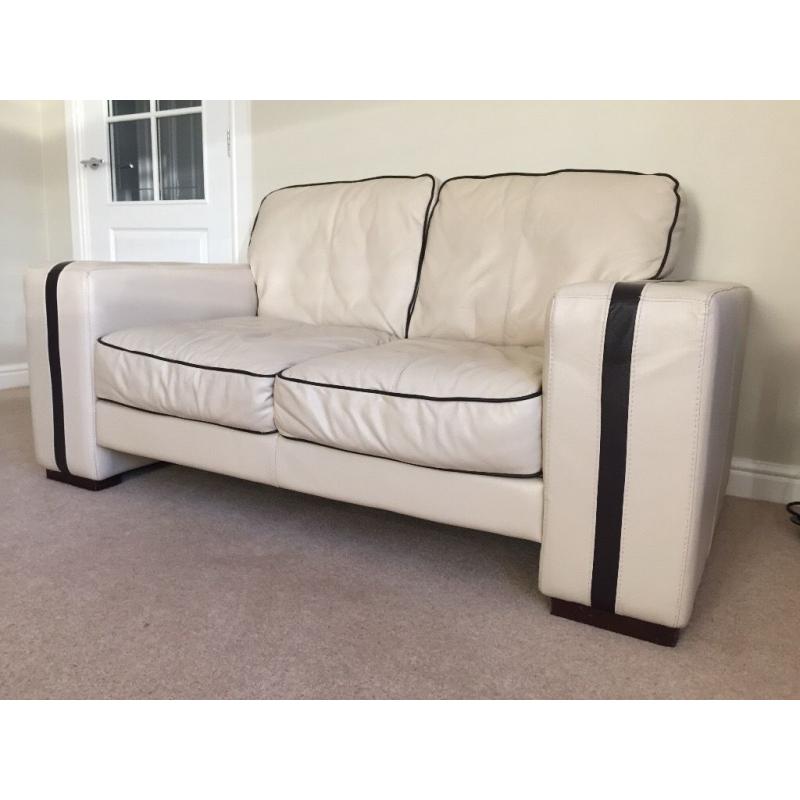 2 x 2 seater leather cream sofa with dark brown trim and footstool