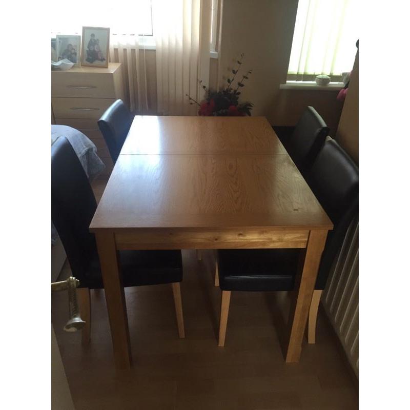 Wooden extendable table with 4 black chairs